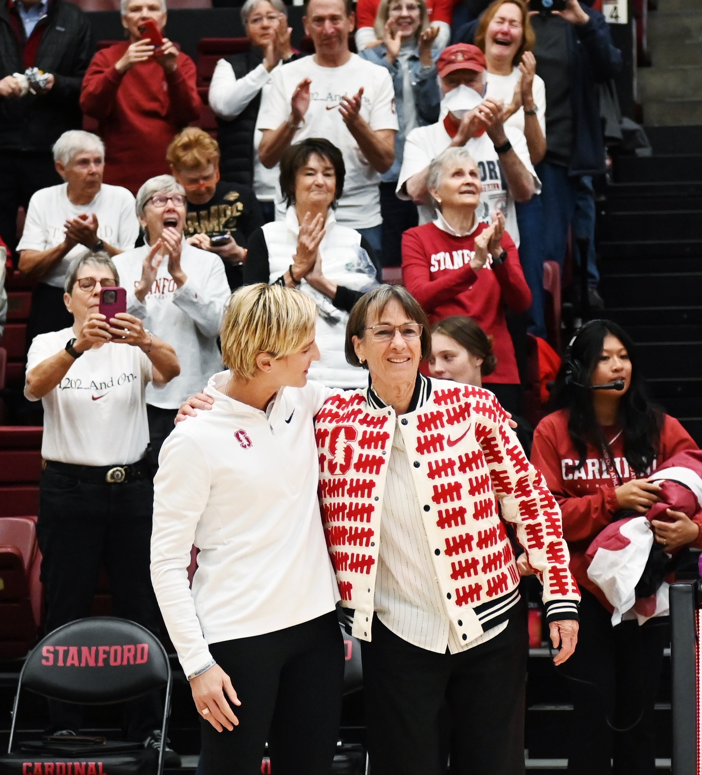 Stanford, CA – November 10, 2024. Stanford head coach Kate Paye and Stanford legend Tara VanDerveer embrace at the unveiling of Tara VanDerveer Court in Maples Pavilion. Photo © Baranduin Briggs, all rights reserved.